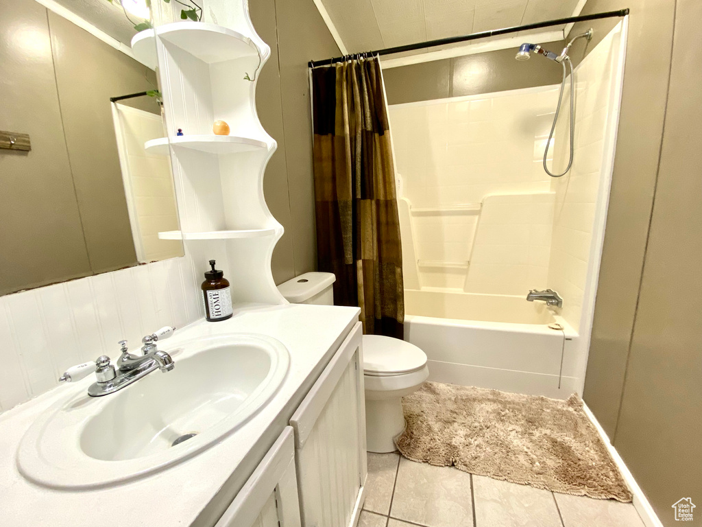 Full bathroom featuring tile flooring, oversized vanity, shower / tub combo, and toilet