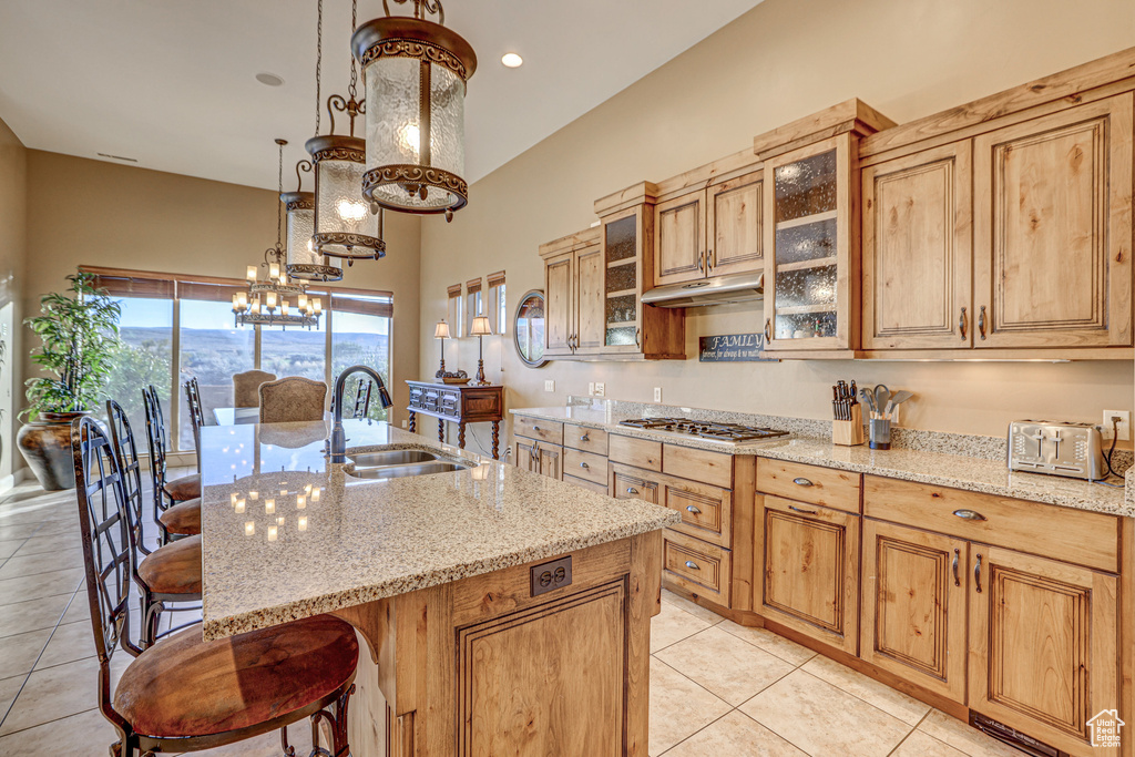 Kitchen with a kitchen breakfast bar, sink, a chandelier, decorative light fixtures, and a center island with sink