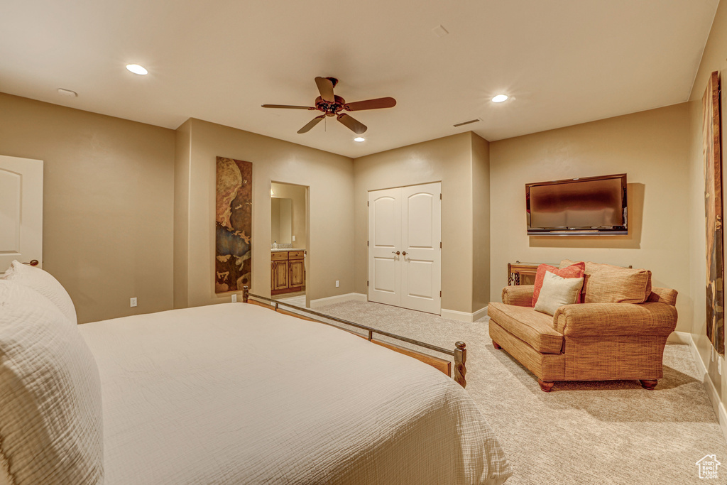 Carpeted bedroom with ensuite bathroom and ceiling fan