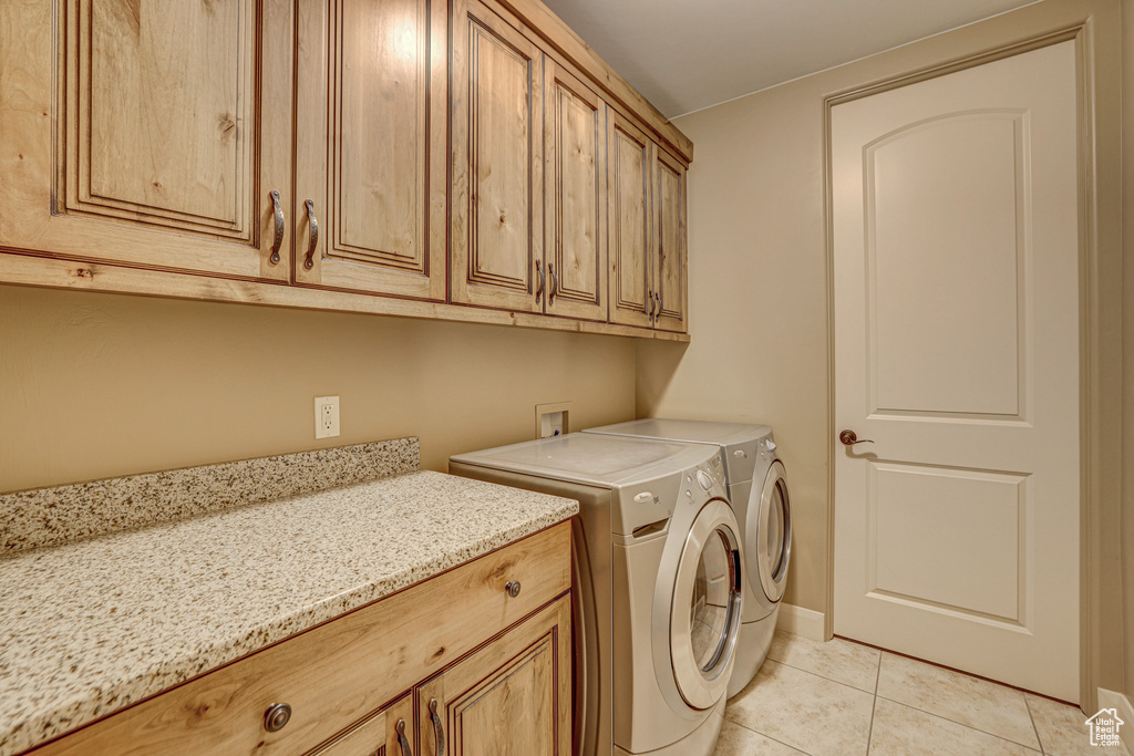 Laundry room with cabinets, hookup for a washing machine, light tile floors, and washer and dryer