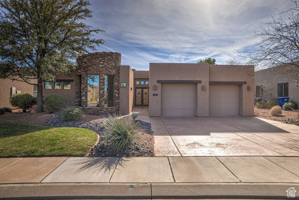 Pueblo-style home featuring a garage