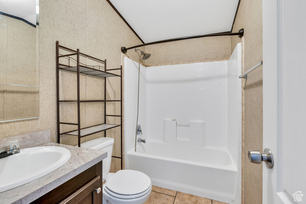 Full bathroom featuring vanity, a textured ceiling, washtub / shower combination, toilet, and tile floors