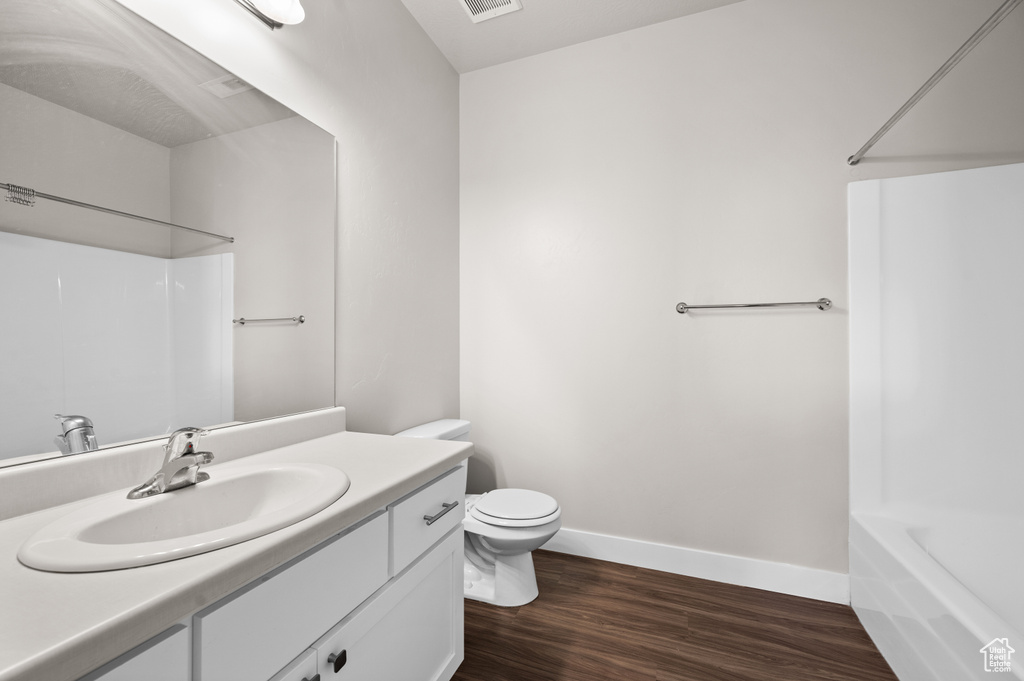 Full bathroom featuring vanity, bathtub / shower combination, toilet, and hardwood / wood-style floors