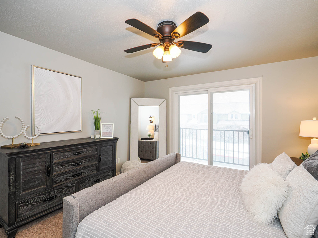 Carpeted bedroom featuring access to outside and ceiling fan