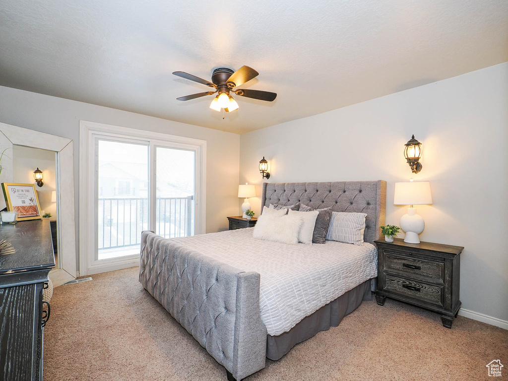 Carpeted bedroom featuring access to exterior and ceiling fan