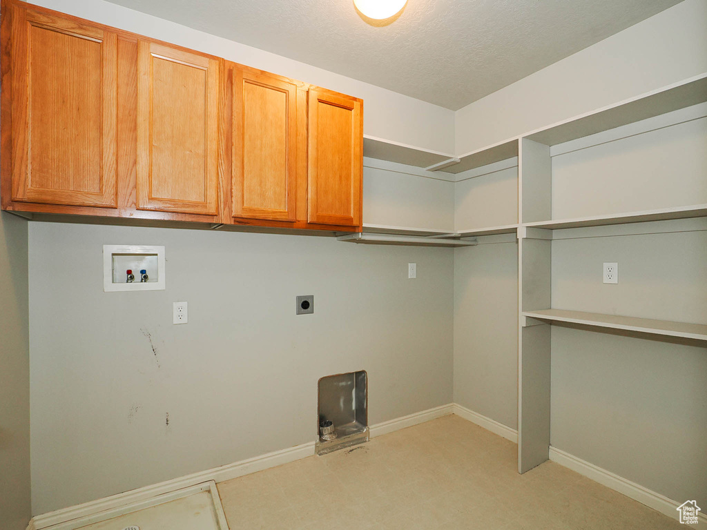 Laundry room featuring cabinets, hookup for a washing machine, light carpet, and electric dryer hookup