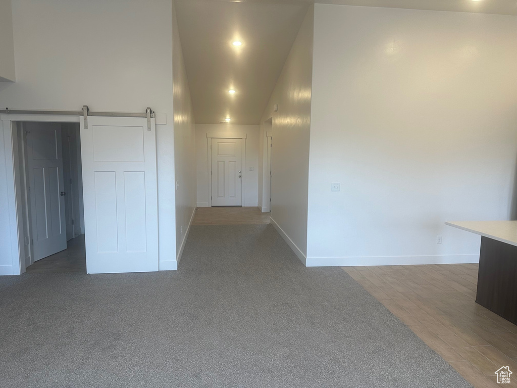 Spare room with a barn door and dark colored carpet