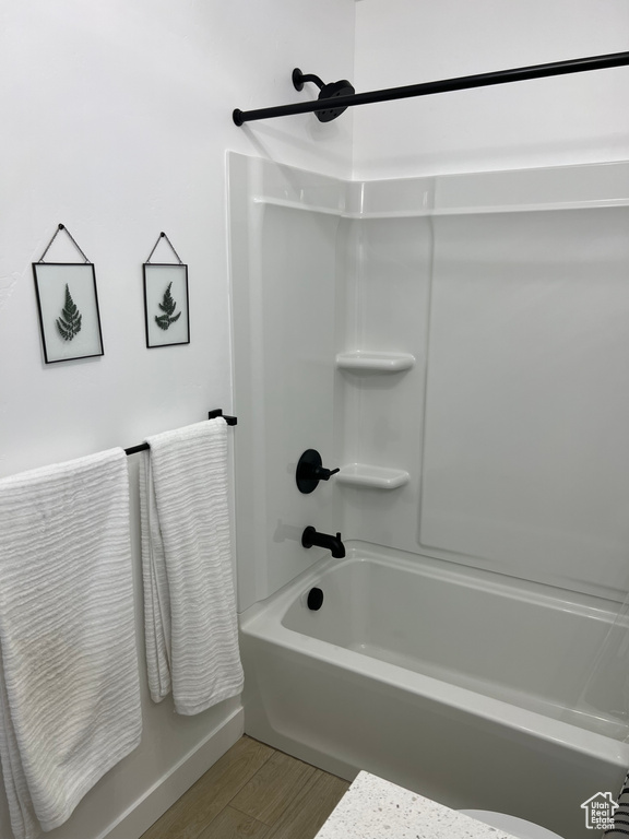 Bathroom with shower / tub combination and wood-type flooring