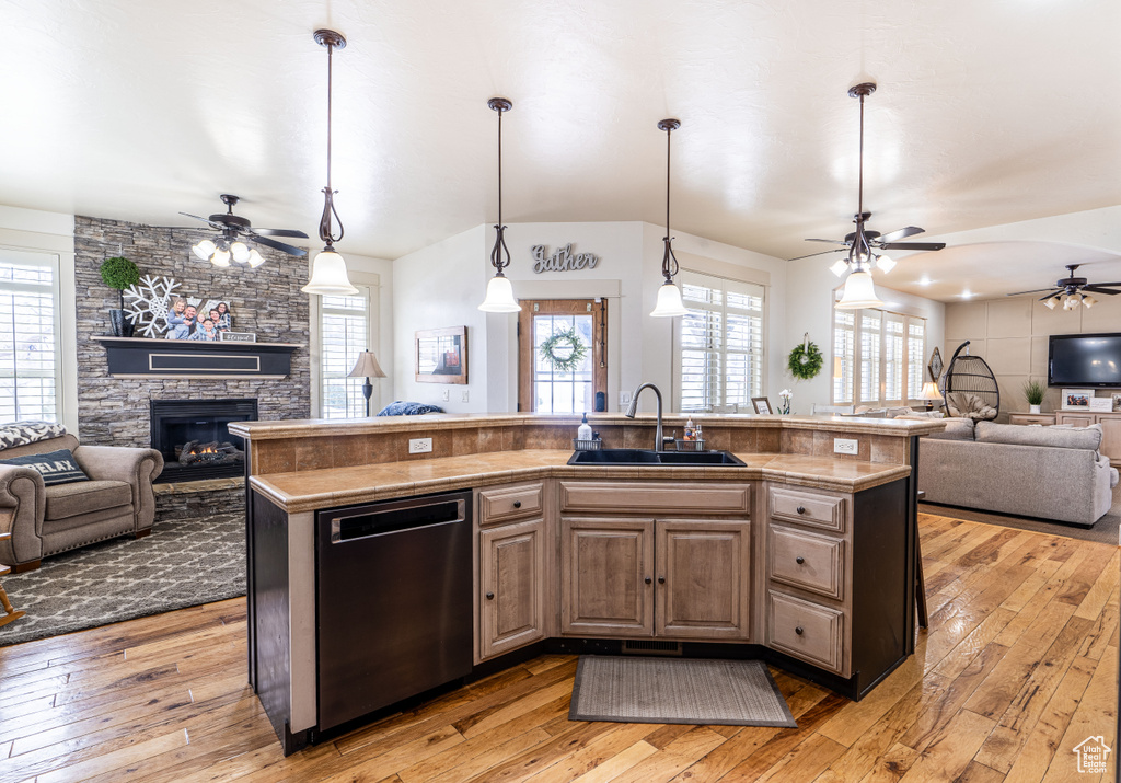 Kitchen with sink, dishwashing machine, light hardwood / wood-style floors, and ceiling fan