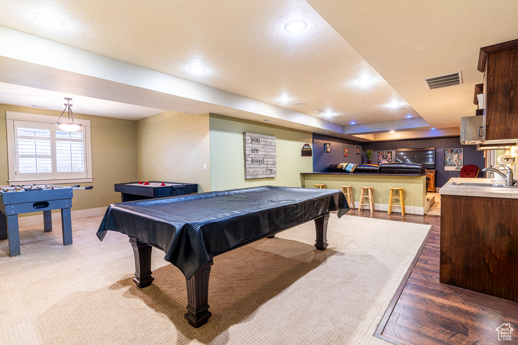 Recreation room with carpet flooring, a raised ceiling, sink, and pool table