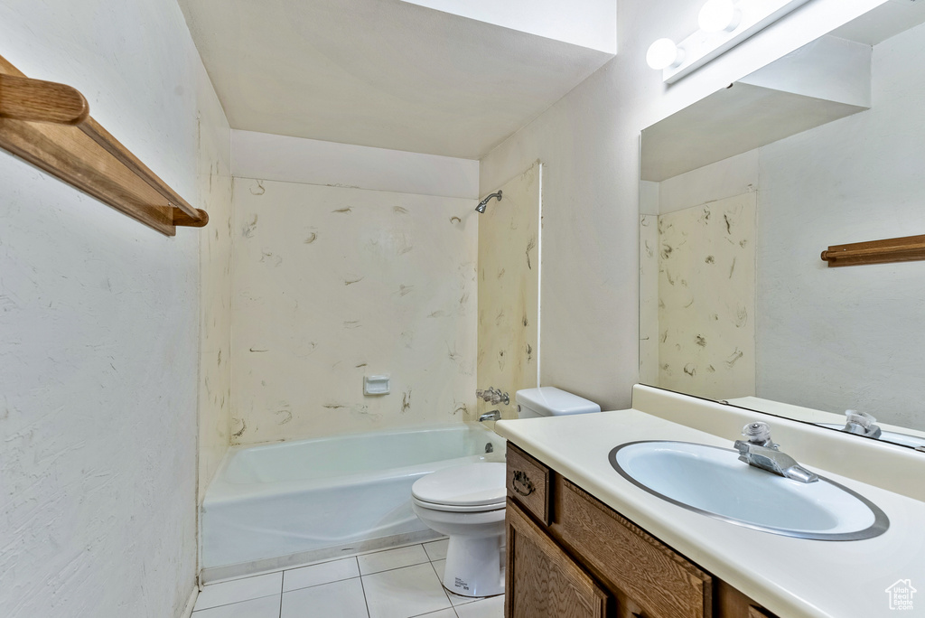 Full bathroom with toilet, vanity with extensive cabinet space, shower / bathtub combination, and tile floors