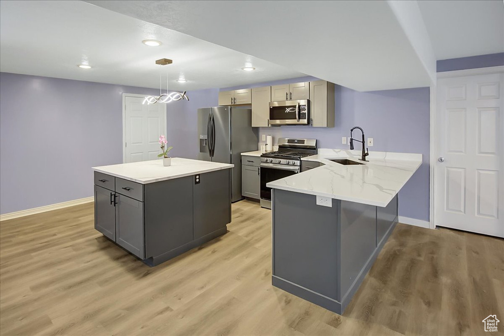 Kitchen featuring stainless steel appliances, sink, gray cabinetry, and light hardwood / wood-style floors