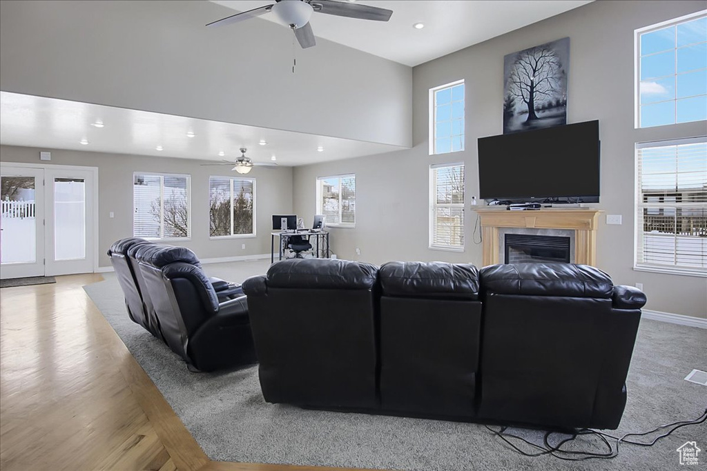 Living room featuring ceiling fan and a high ceiling