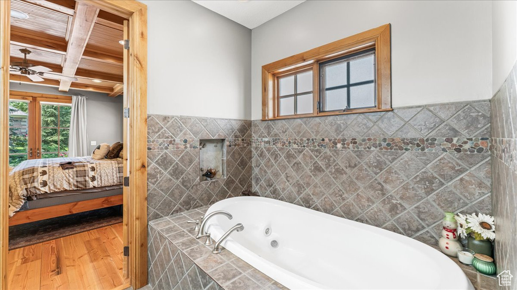 Bathroom featuring hardwood / wood-style floors, tile walls, coffered ceiling, beamed ceiling, and ceiling fan