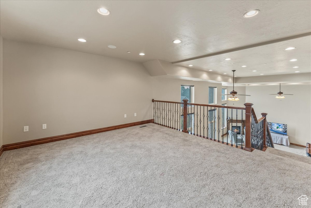 Basement with light colored carpet and ceiling fan