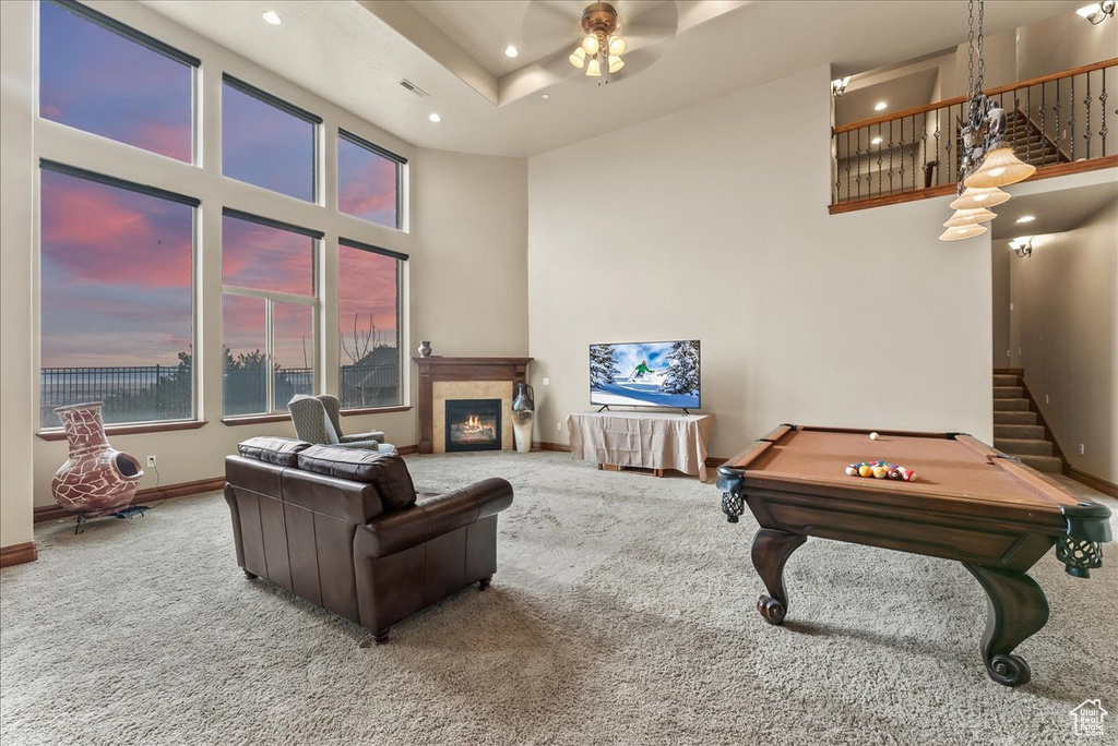 Recreation room featuring ceiling fan, carpet, a raised ceiling, a towering ceiling, and billiards