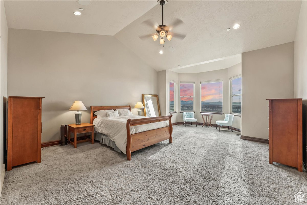 Carpeted bedroom with high vaulted ceiling and ceiling fan
