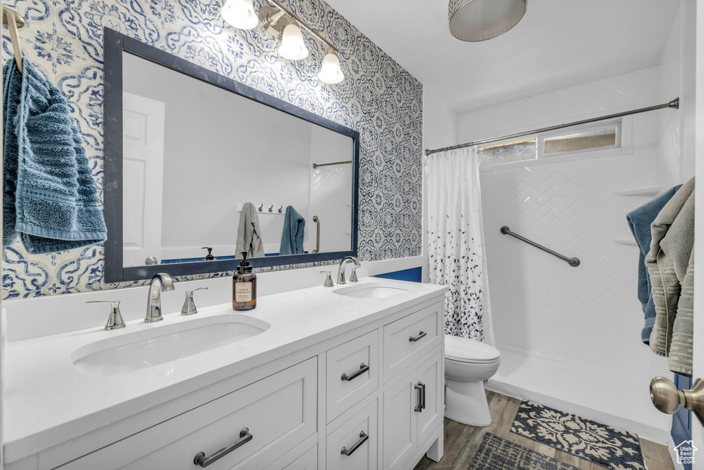 Bathroom with dual sinks, toilet, a shower with shower curtain, and large vanity
