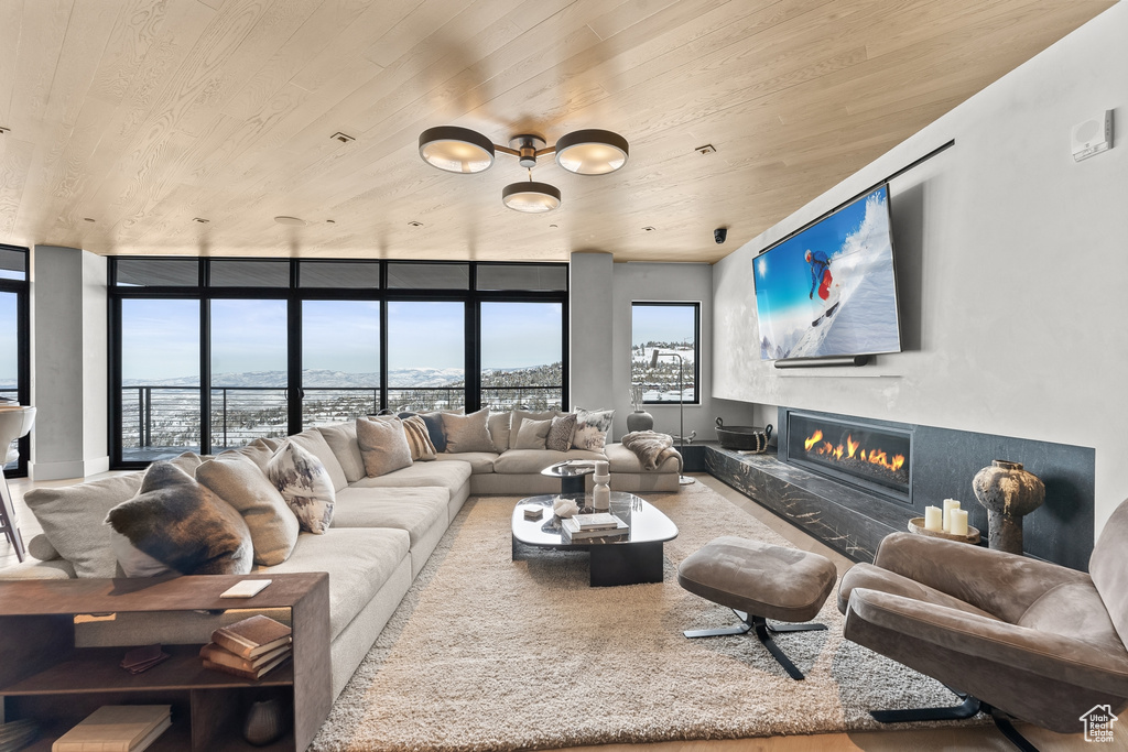 Living room featuring wooden ceiling and a wall of windows