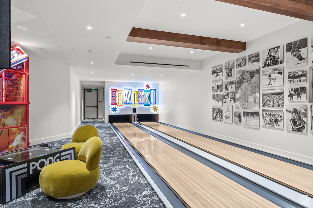 Recreation room featuring a bowling alley and beamed ceiling
