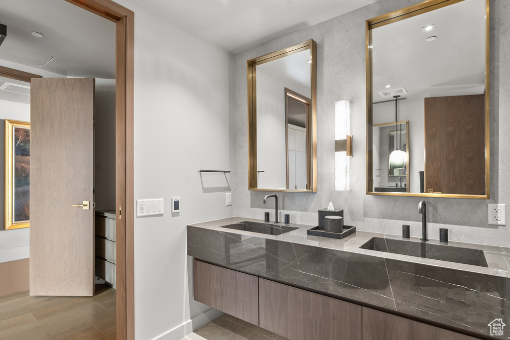 Bathroom with vanity, tasteful backsplash, and hardwood / wood-style floors