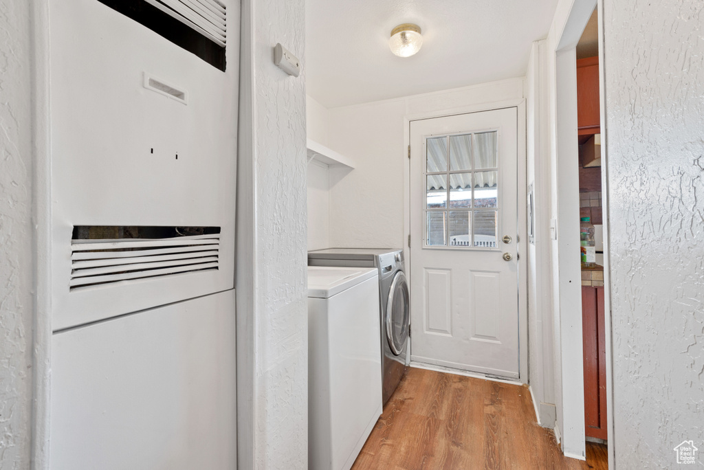 Laundry room with light wood-type flooring and independent washer and dryer