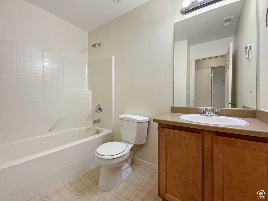 Full bathroom featuring vanity, toilet, tile flooring, and bathtub / shower combination