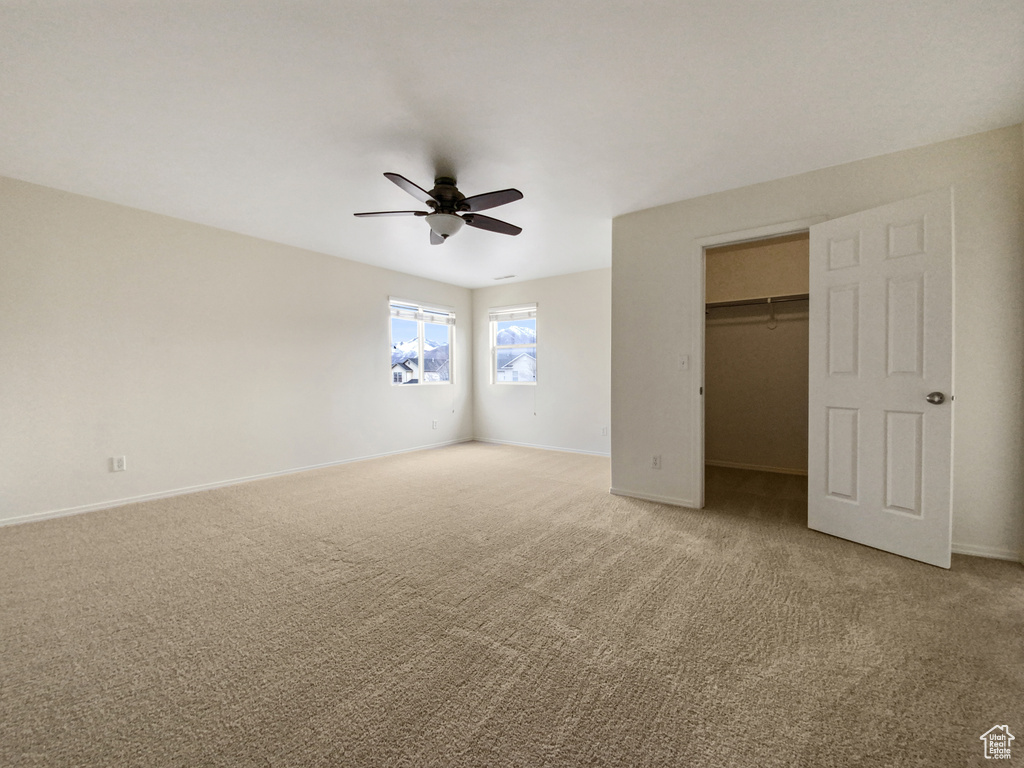 Unfurnished bedroom featuring light carpet, a closet, and ceiling fan