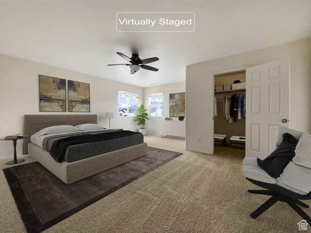 Bedroom featuring a spacious closet, light colored carpet, a closet, and ceiling fan