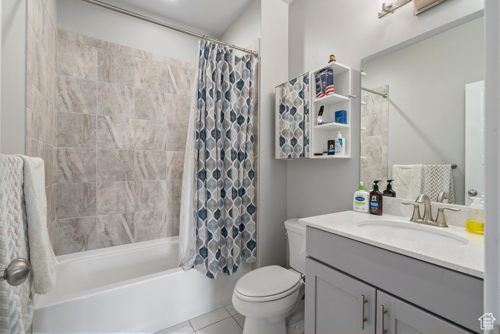 Full bathroom with oversized vanity, shower / bathtub combination with curtain, tile flooring, and toilet