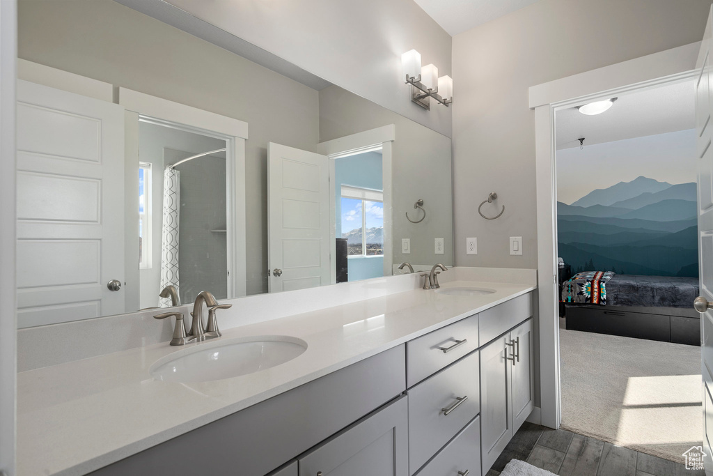 Bathroom with double sink, oversized vanity, and hardwood / wood-style floors