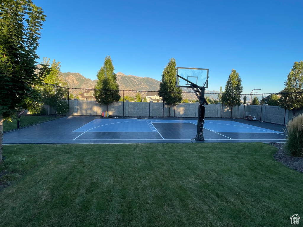 View of basketball court with a mountain view and a lawn