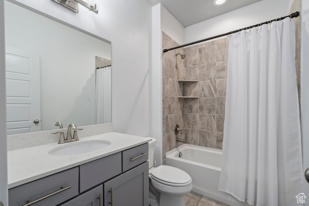 Full bathroom with vanity, tile flooring, shower / bath combo with shower curtain, and toilet