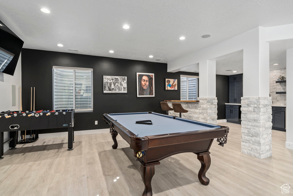 Recreation room with light wood-type flooring, decorative columns, and pool table