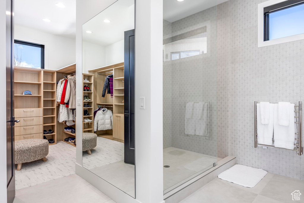 Bathroom featuring tiled shower, radiator heating unit, and tile floors