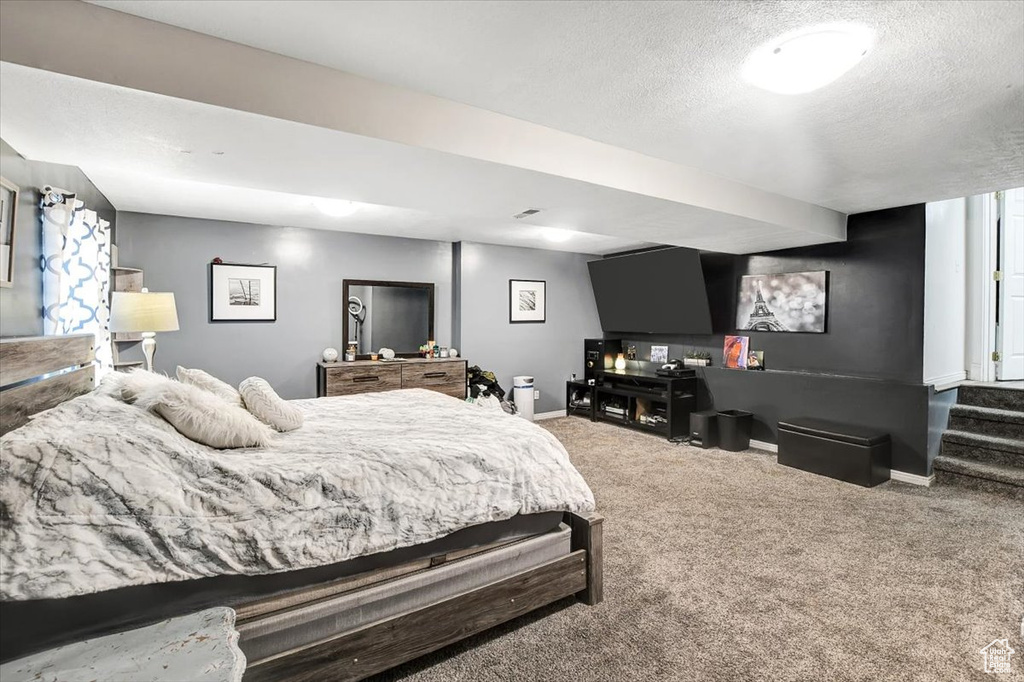 Bedroom featuring a textured ceiling and dark carpet
