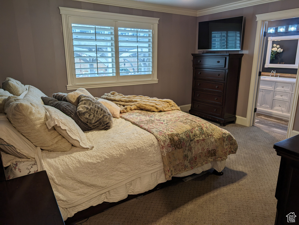 Bedroom featuring carpet, ensuite bathroom, sink, and crown molding