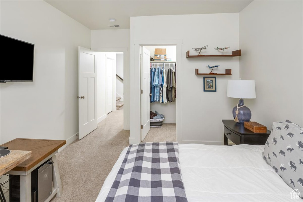 Carpeted bedroom featuring a closet and a walk in closet