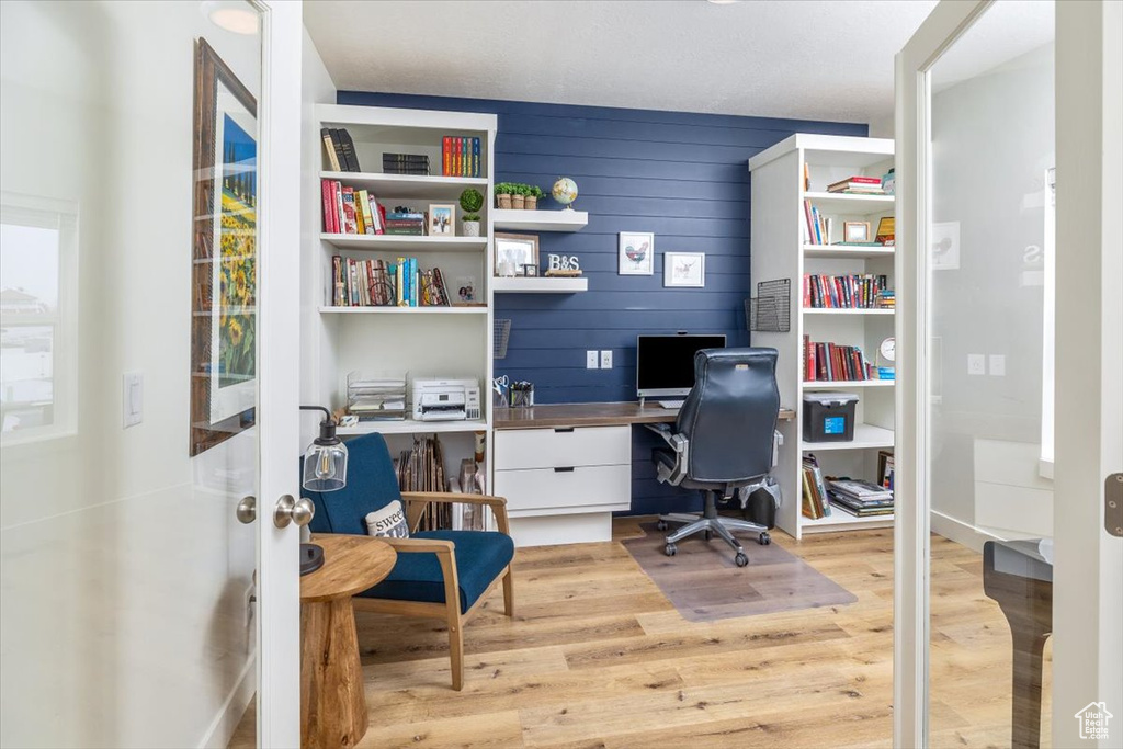 Home office featuring light hardwood / wood-style flooring and built in desk