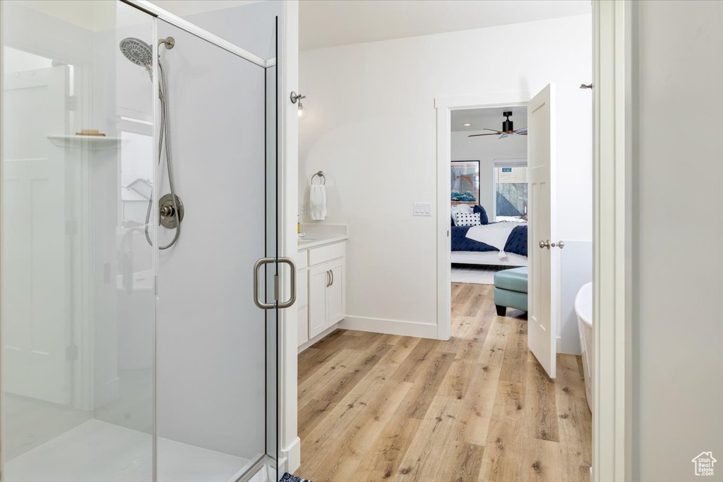 Bathroom with ceiling fan, walk in shower, vanity, and hardwood / wood-style floors