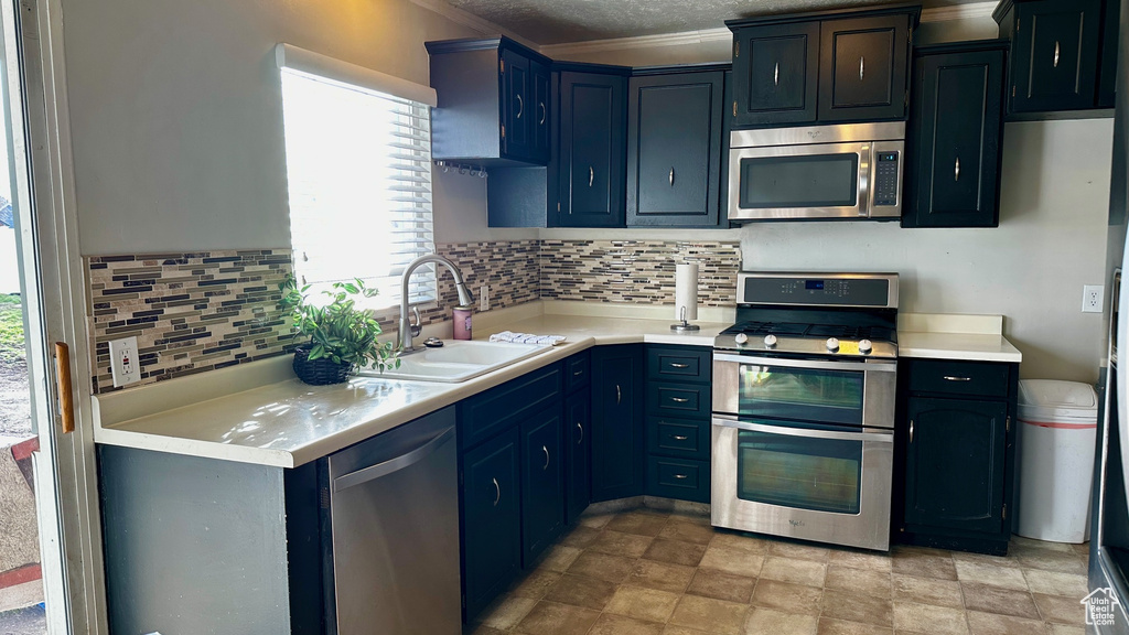 Kitchen with backsplash, light tile flooring, stainless steel appliances, and sink