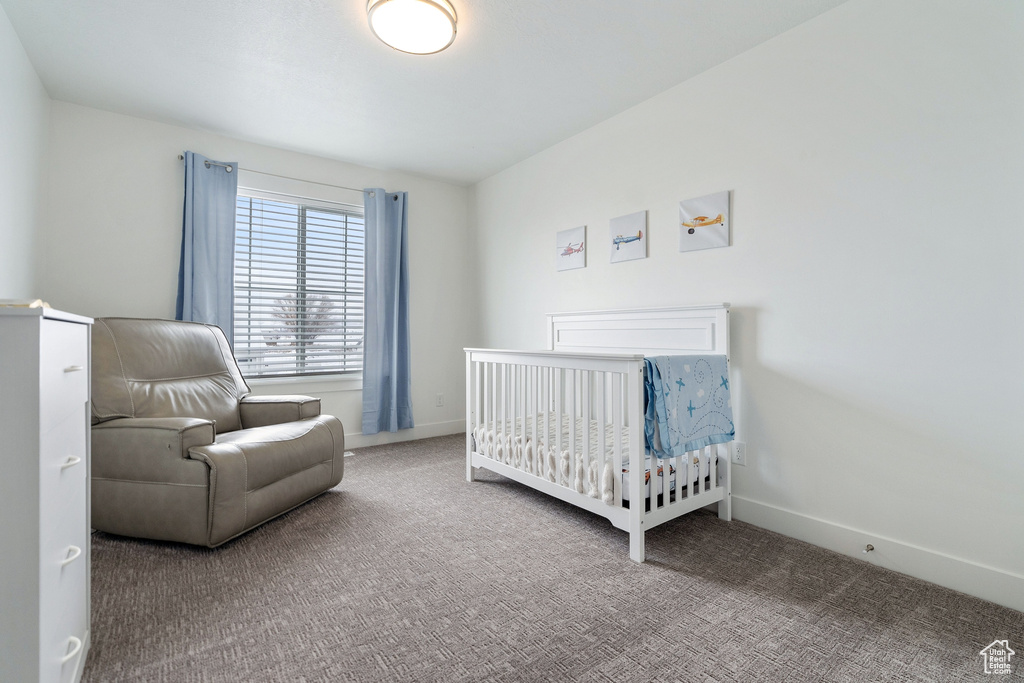 Bedroom with light carpet and a crib