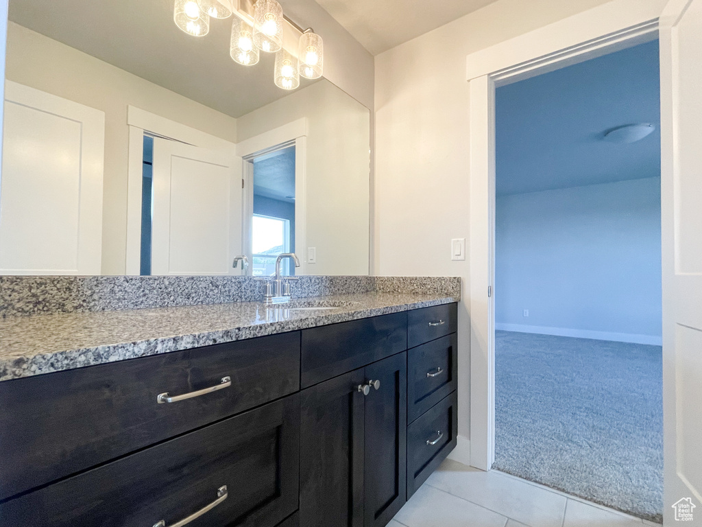 Bathroom with tile floors, a notable chandelier, and oversized vanity