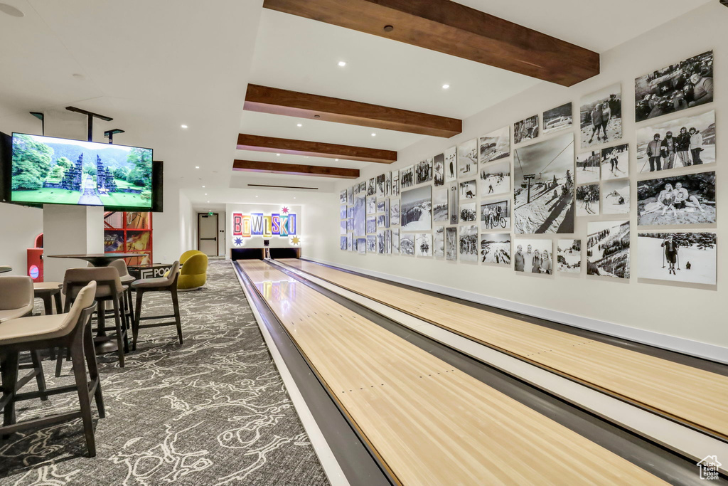 Rec room featuring a bowling alley and beam ceiling