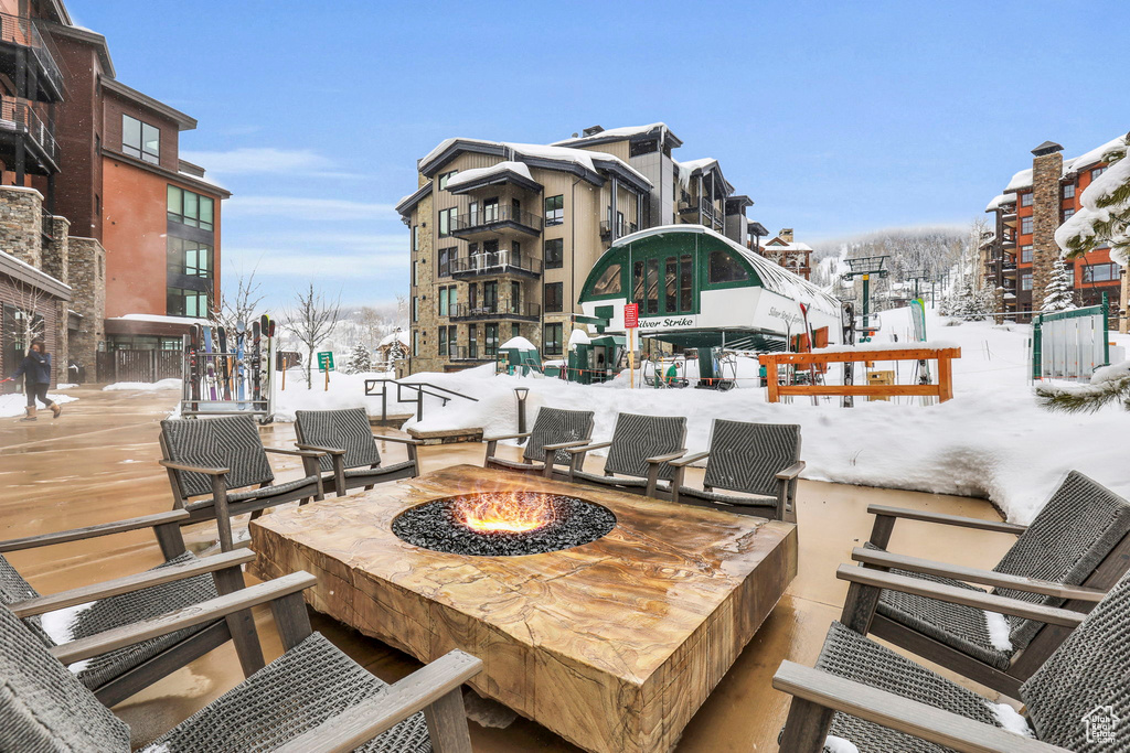 Snow covered patio with an outdoor fire pit