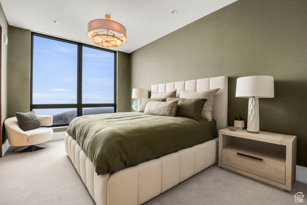 Bedroom featuring light colored carpet and floor to ceiling windows