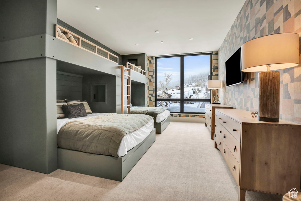 Bedroom with light carpet and floor to ceiling windows