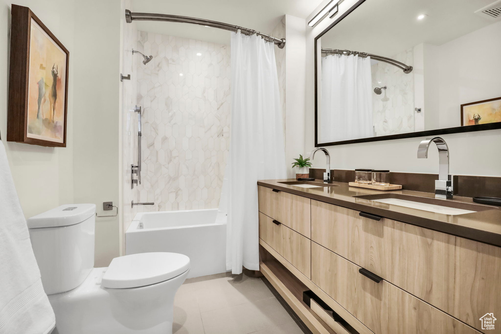 Full bathroom with oversized vanity, toilet, shower / bath combo, and tile floors