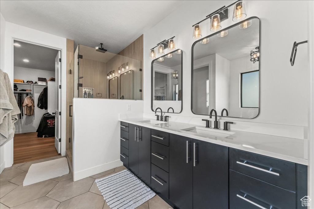 Bathroom with dual vanity and hardwood / wood-style flooring
