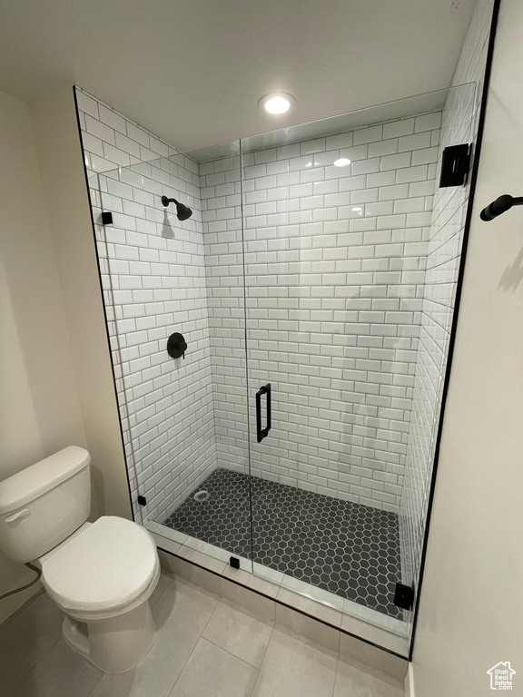 Bathroom with tile flooring, toilet, and walk in shower